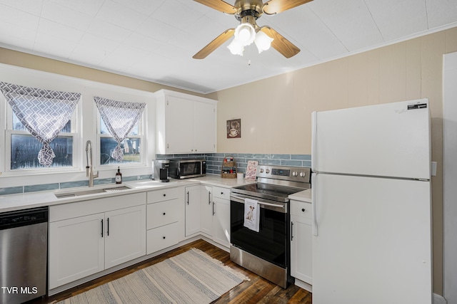 kitchen featuring dark wood-style floors, light countertops, appliances with stainless steel finishes, white cabinetry, and a sink