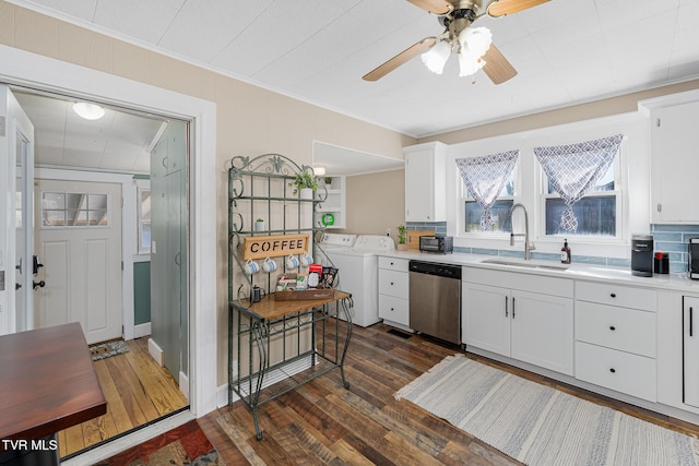 kitchen featuring dark wood-type flooring, light countertops, stainless steel dishwasher, separate washer and dryer, and a sink