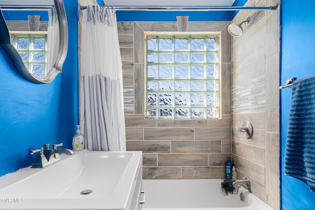 bathroom featuring shower / bath combination with curtain and a sink