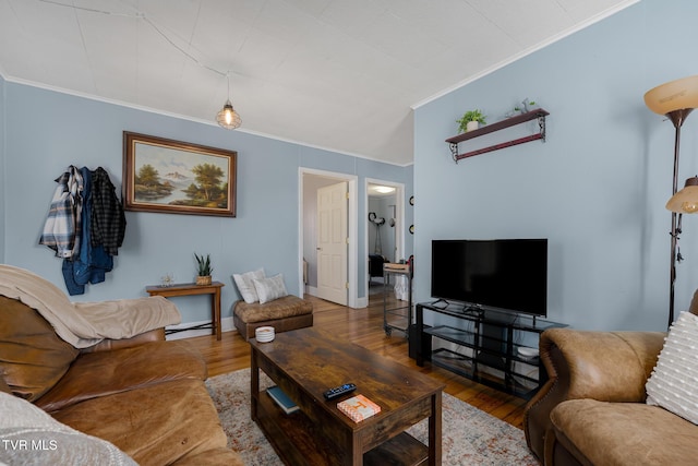 living room with ornamental molding, a baseboard heating unit, baseboards, and wood finished floors