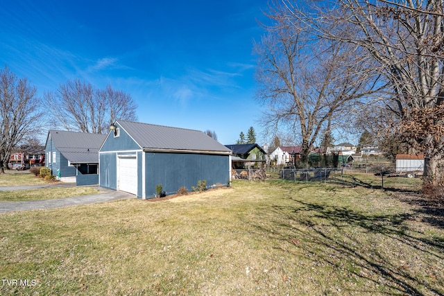 exterior space with aphalt driveway, fence, metal roof, and a yard