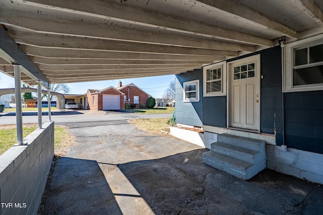 view of patio / terrace with entry steps, a carport, and aphalt driveway