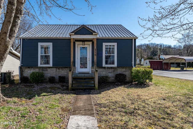 bungalow-style home with central air condition unit, stone siding, metal roof, and entry steps