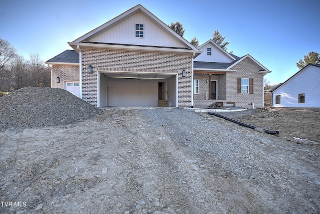 view of front of home with an attached garage, driveway, and brick siding