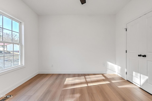 spare room with visible vents, light wood-style flooring, and baseboards