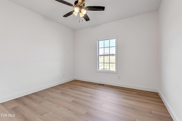 spare room with light wood-type flooring, baseboards, visible vents, and a ceiling fan