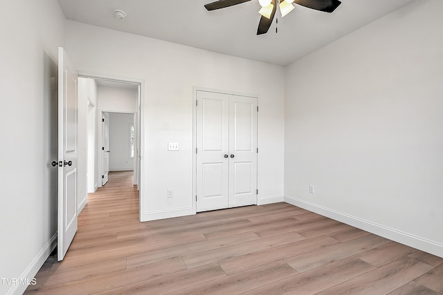 unfurnished bedroom with a ceiling fan, a closet, light wood-style flooring, and baseboards