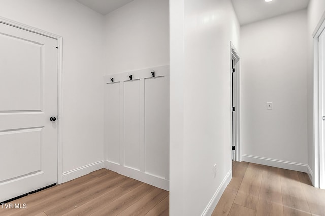 mudroom featuring light wood-style flooring and baseboards