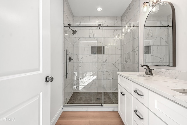 full bath featuring a stall shower, recessed lighting, wood finished floors, and vanity