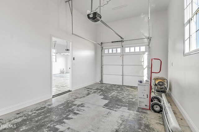 garage with a garage door opener and baseboards