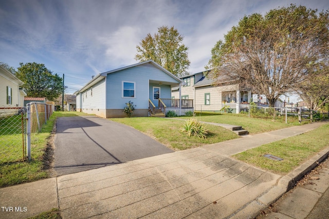 view of front of home featuring a front yard, fence, and covered porch