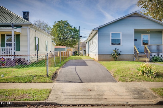 view of side of property featuring a standing seam roof, a yard, and fence