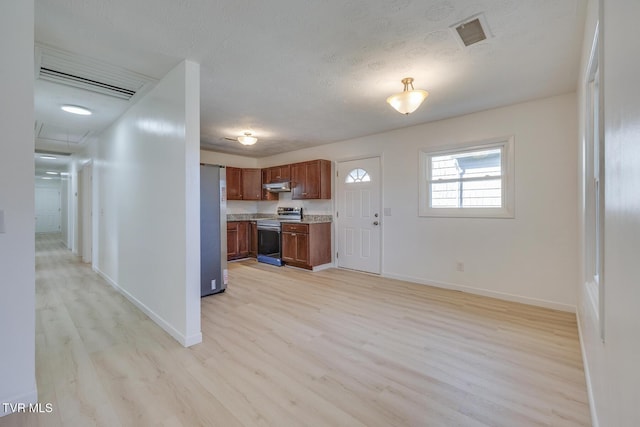 kitchen featuring visible vents, light countertops, brown cabinets, light wood-style floors, and stainless steel appliances