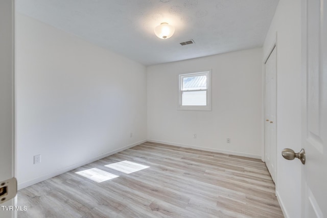 unfurnished bedroom with visible vents, baseboards, and light wood-style floors