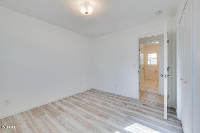 empty room with light wood-type flooring and baseboards