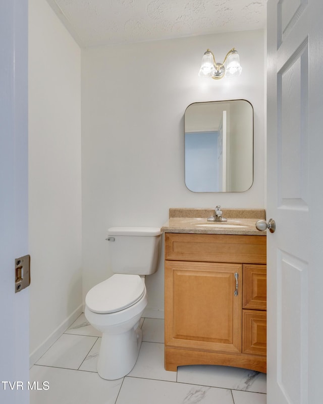 bathroom with baseboards, toilet, marble finish floor, and vanity