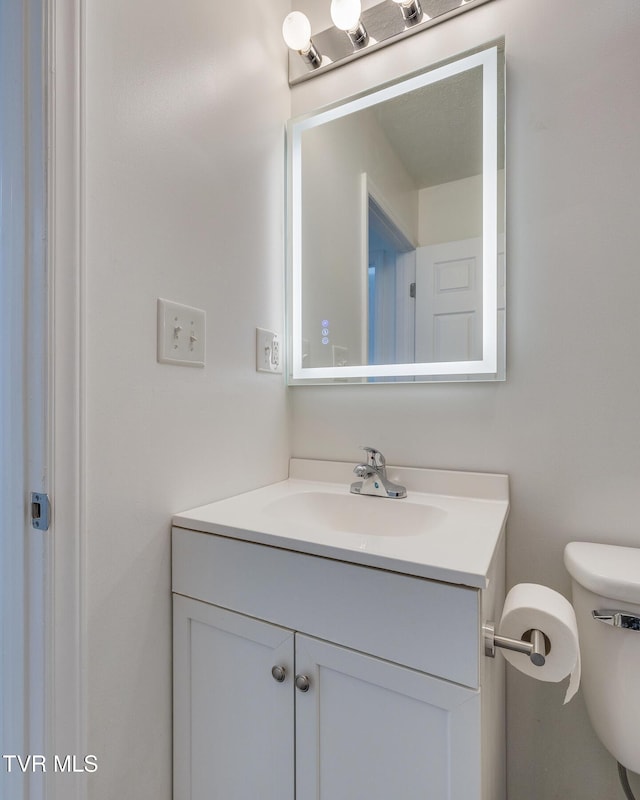 half bath featuring toilet and vanity