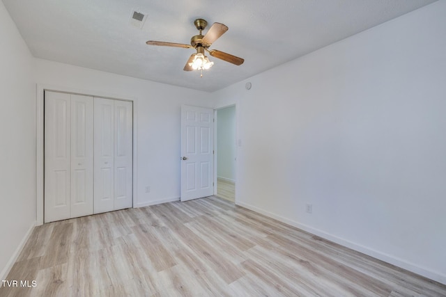 unfurnished bedroom with a ceiling fan, visible vents, baseboards, a closet, and light wood-type flooring