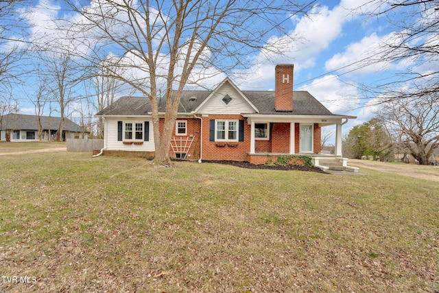 view of front facade featuring brick siding, a chimney, and a front yard