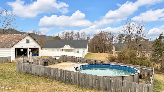 view of swimming pool with an outbuilding, a fenced in pool, a lawn, and a fenced backyard