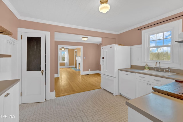 kitchen with a wealth of natural light, white appliances, crown molding, and a sink