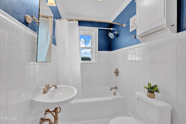 bathroom featuring toilet, tile walls, shower / bath combo, and a sink