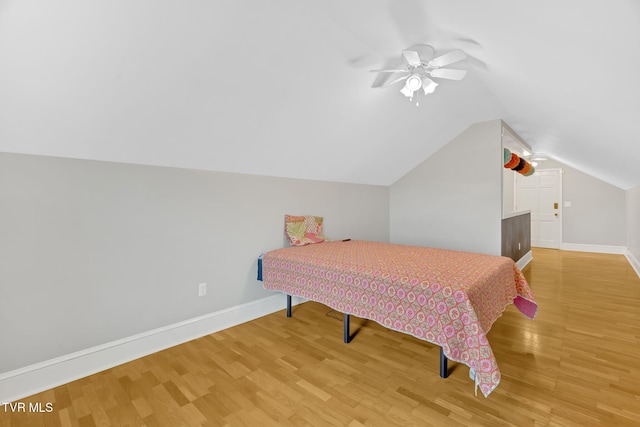 bedroom with ceiling fan, baseboards, lofted ceiling, and light wood-style floors