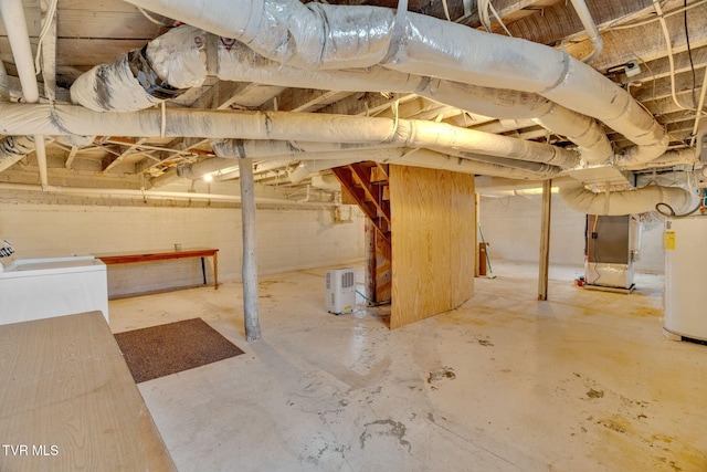 unfinished basement with water heater, heating unit, and washer / dryer