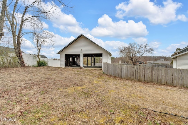 rear view of house with an outbuilding, an outdoor structure, and fence