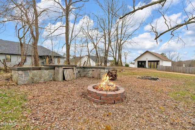 view of yard with an outbuilding, fence, and an outdoor fire pit