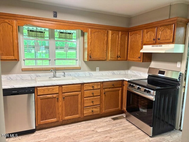 804 E Maple St, Johnson City, TN 37601 - kitchen featuring stainless steel appliances, under cabinet range hood, a sink, brown cabinetry, and light wood-type flooring