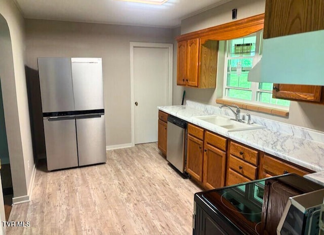 804 E Maple St, Johnson City, TN 37601 - kitchen featuring appliances with stainless steel finishes, a sink, brown cabinetry, and light wood-style floors