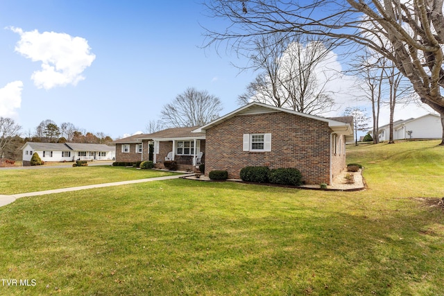 single story home with brick siding and a front yard