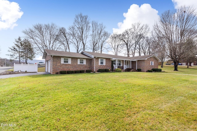 ranch-style house featuring an attached garage, a front lawn, aphalt driveway, and brick siding