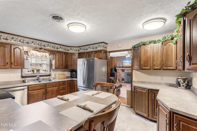 kitchen featuring a textured ceiling, a sink, visible vents, light countertops, and appliances with stainless steel finishes