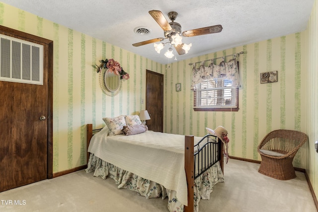 carpeted bedroom with visible vents, a textured ceiling, baseboards, and wallpapered walls