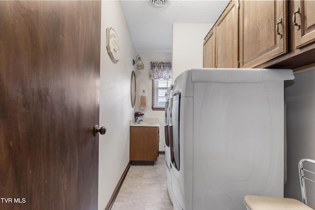 clothes washing area with laundry area, baseboards, and a textured ceiling