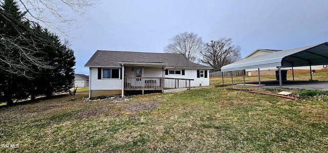 rear view of property featuring a detached carport, a yard, and a deck