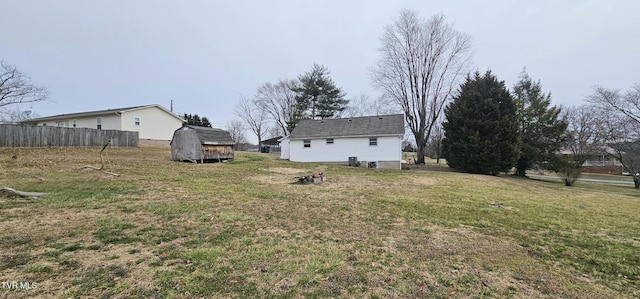 view of yard featuring a shed, fence, and an outdoor structure