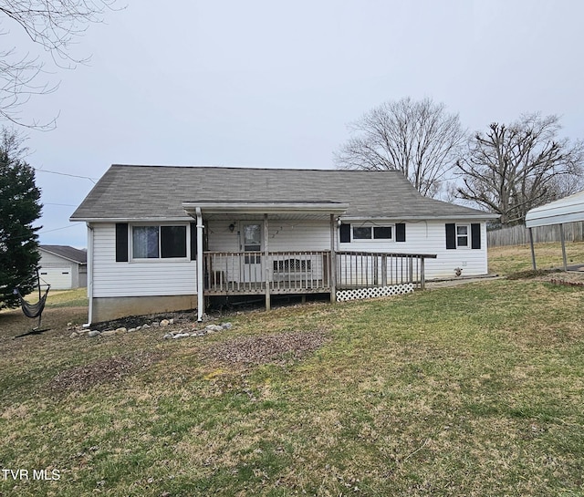 rear view of house with fence, a deck, and a lawn