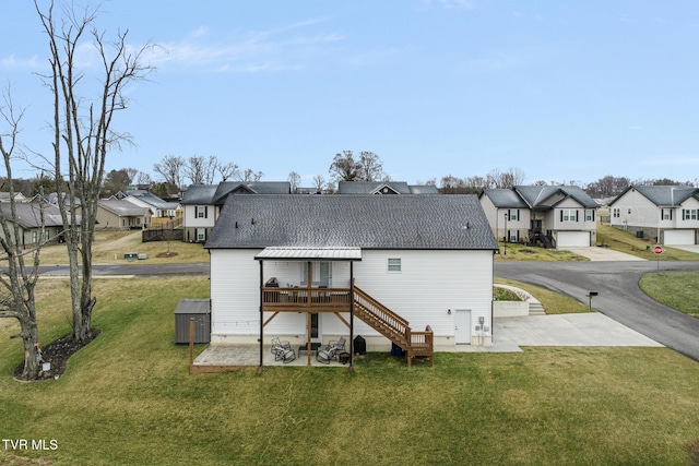 back of house featuring a residential view, a patio area, a lawn, and a wooden deck