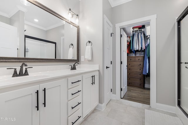 bathroom featuring ornamental molding, a stall shower, and a sink