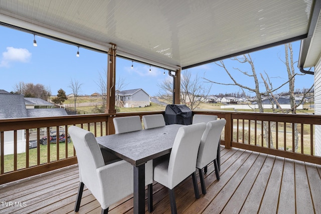 wooden deck with a residential view, outdoor dining area, and grilling area