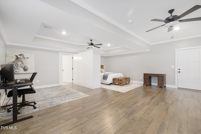 interior space with ornamental molding, a raised ceiling, and wood finished floors