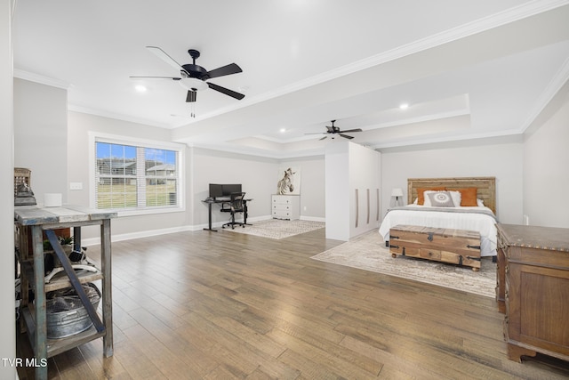 bedroom with crown molding, recessed lighting, a raised ceiling, wood finished floors, and baseboards