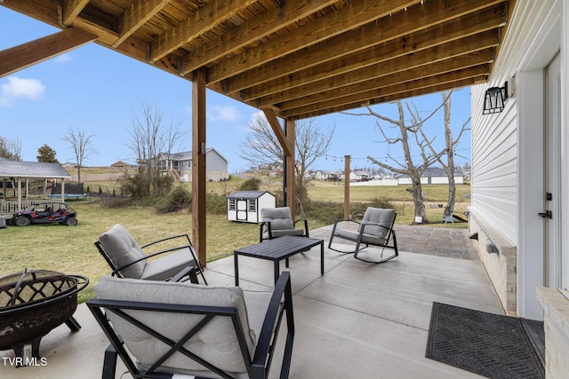 view of patio with a storage shed, an outdoor living space, and an outbuilding