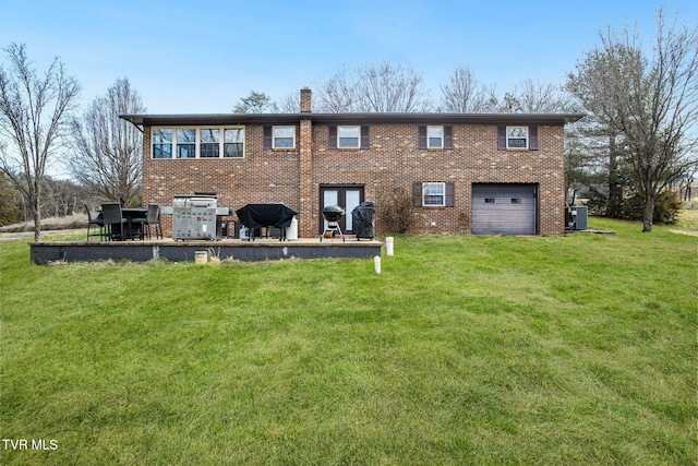 rear view of house featuring a chimney, an attached garage, a yard, central air condition unit, and brick siding