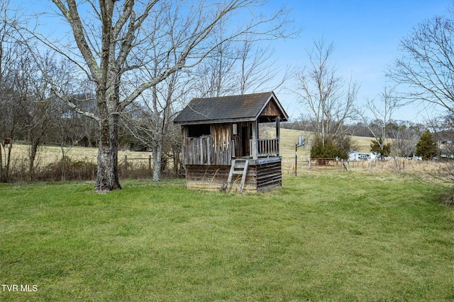 view of yard featuring fence and an outbuilding