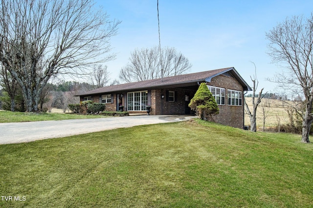 ranch-style house featuring brick siding, driveway, and a front lawn