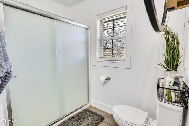 full bathroom featuring wood finished floors, a shower stall, toilet, and baseboards